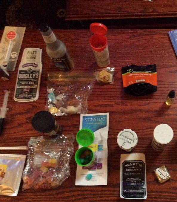 An array of legal consumable marijuana products, including edibles such as THC-infused gummy bears and salt water taffy, liquid for baking, and smoking form.