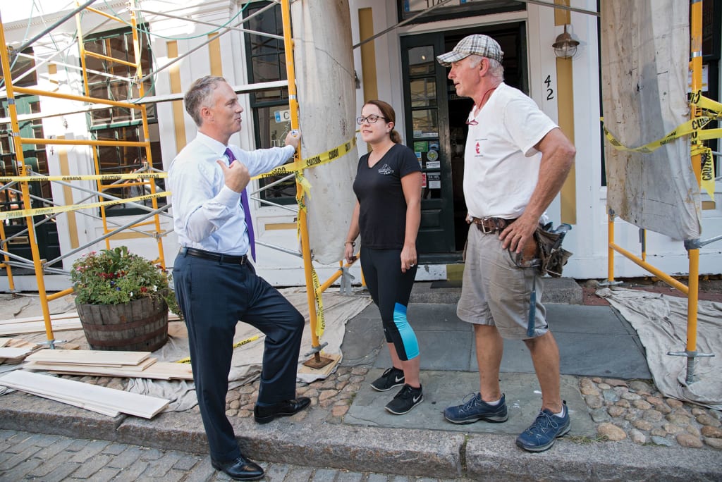 On Water Street in New Bedford, Mayor Jon Mitchell chats with Jessica Coelho, owner of Tia Maria's European Cafe, and Chuck Rooney of Centerline Carpentry in Mattapoisett.