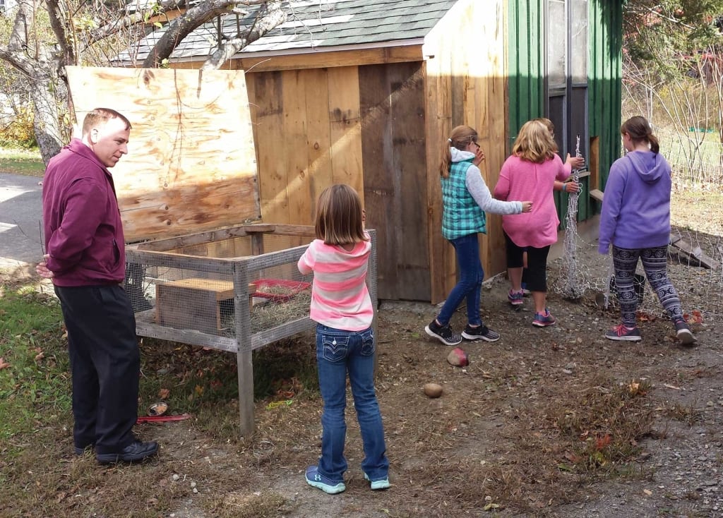 Supt. Michael Buoniconti checks on rabbit hutch with student at Hawlemont Elementary School.
