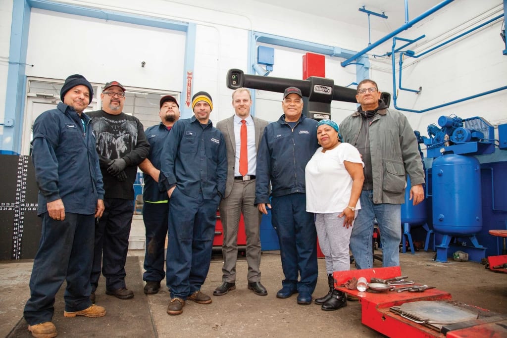 Jose Rosario, third from right, with his employees at Universal Auto Repair and Derek Mitchell (in suit), executive director of the Lawrence Partnership.